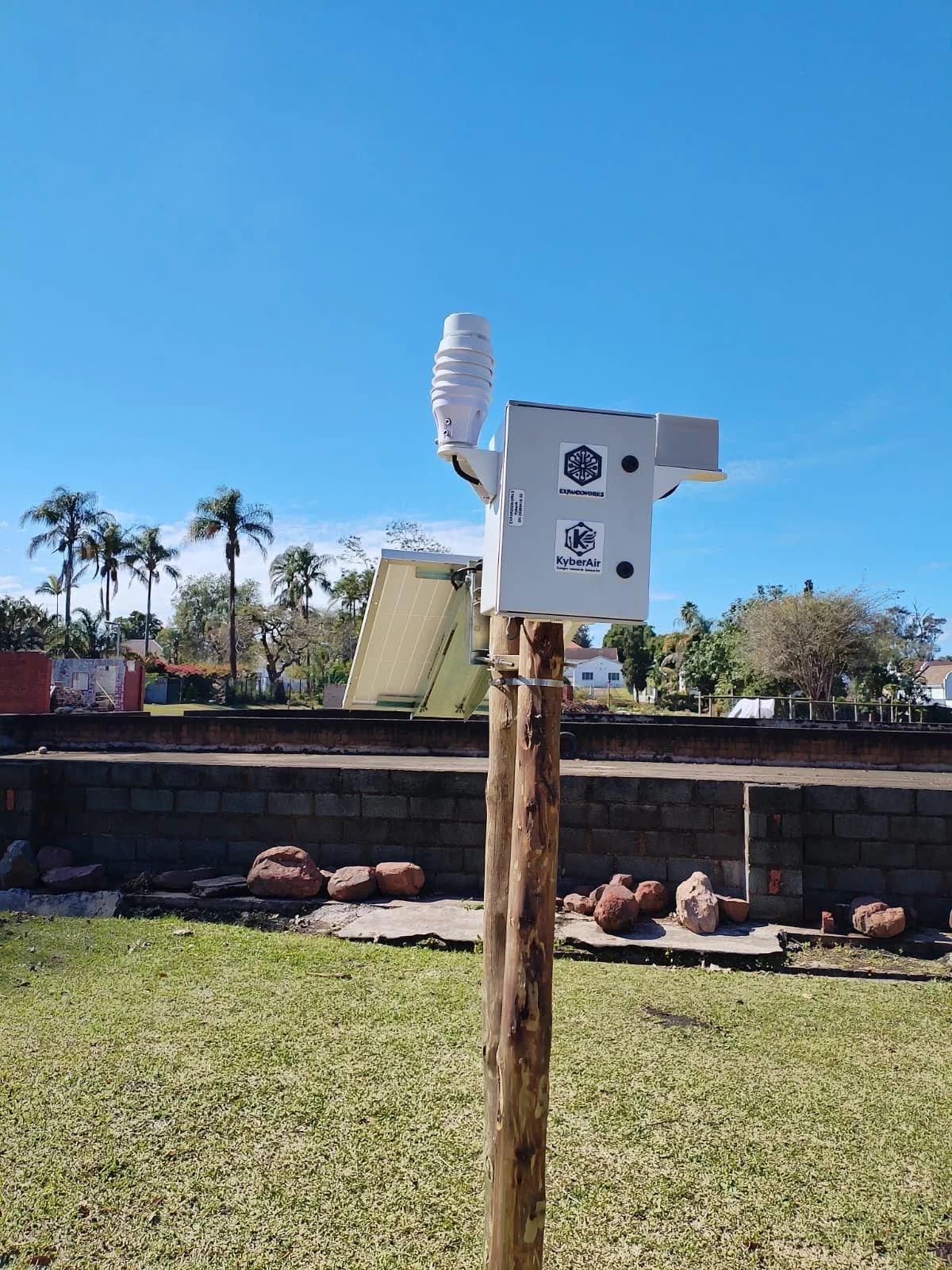 KyberAir enclosure and sensors mounted above a solar panel on a wooden pole