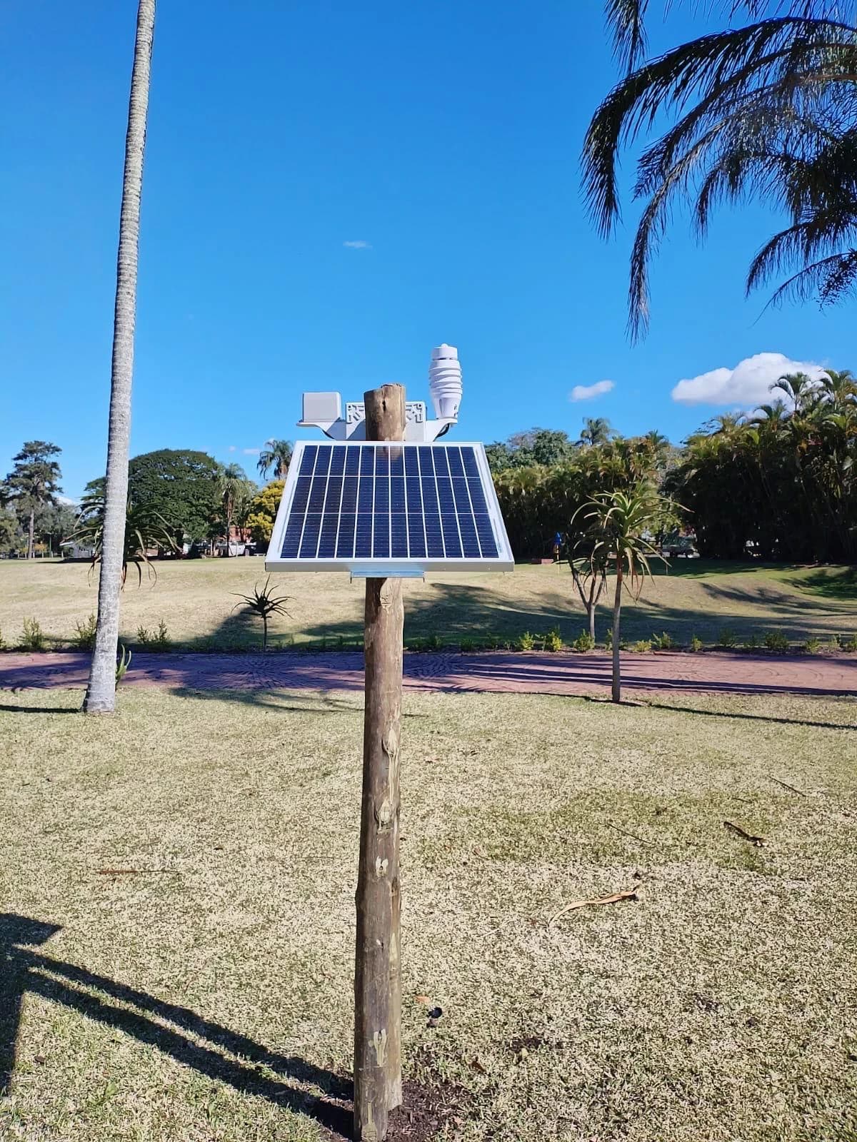 Solar panel and KyberAir sensors mounted on a wooden pole outdoors